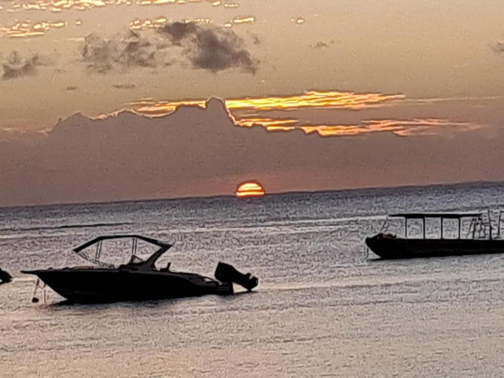 two boats in the water with the sunset in the background at IZS MAURICE in Trou aux Biches