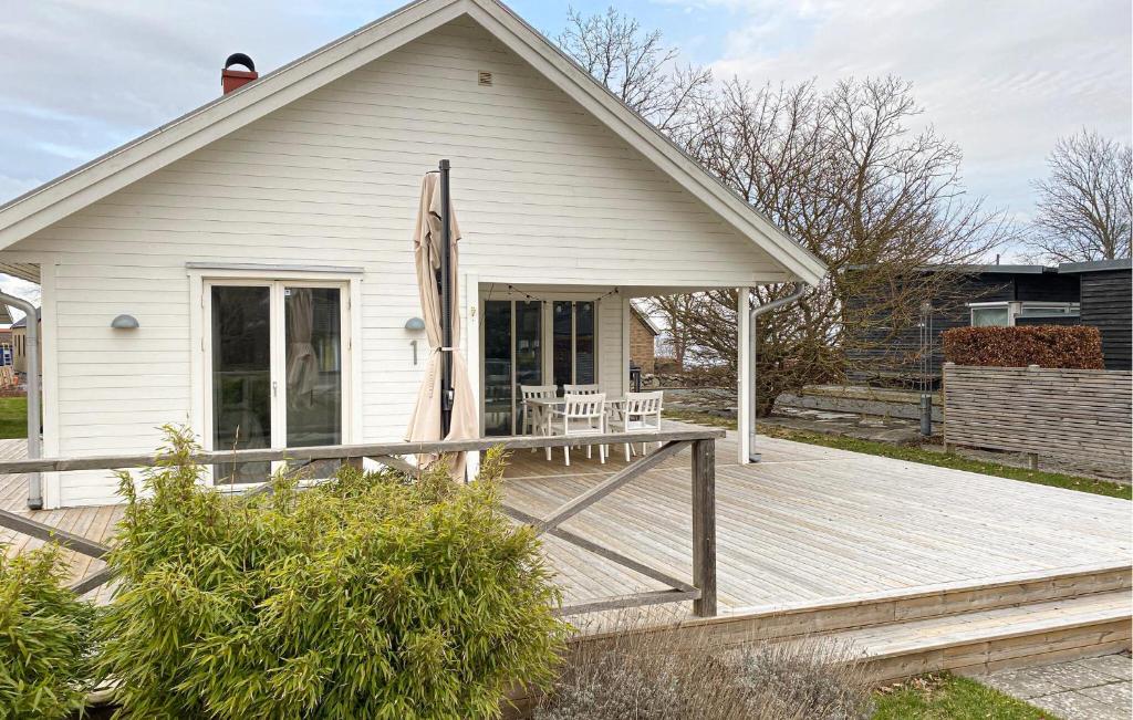 Cette maison blanche dispose d'une terrasse couverte en bois. dans l'établissement Nice Home In Slvesborg With House Sea View, à Sölvesborg