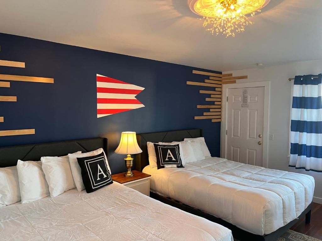 2 camas en un dormitorio con una pared azul en Acadia Ocean View Hotel en Bar Harbor