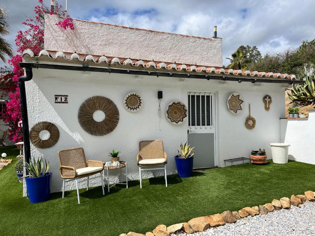 a backyard with chairs and a white house at Villa Casa Rosa, El Torcal in Almogía