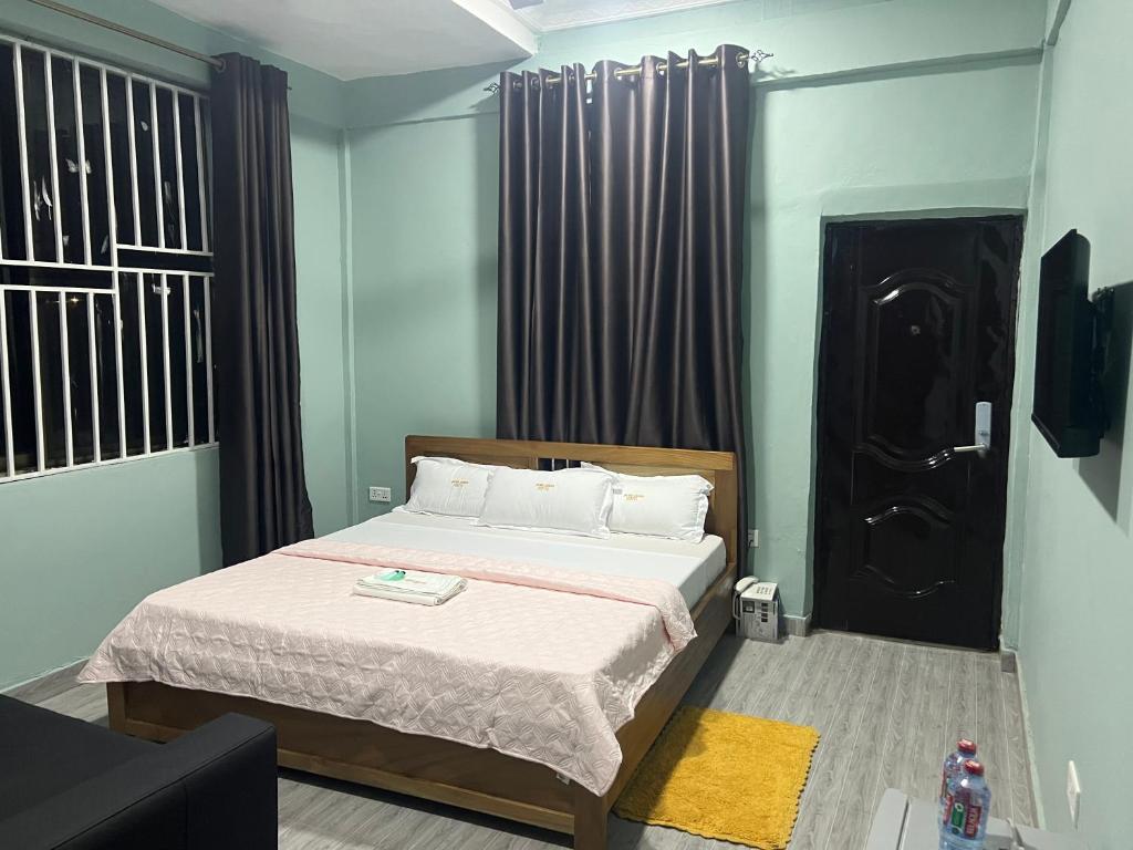 1 dormitorio con cama y puerta negra en Jackie Grand Hotel, en Cape Coast