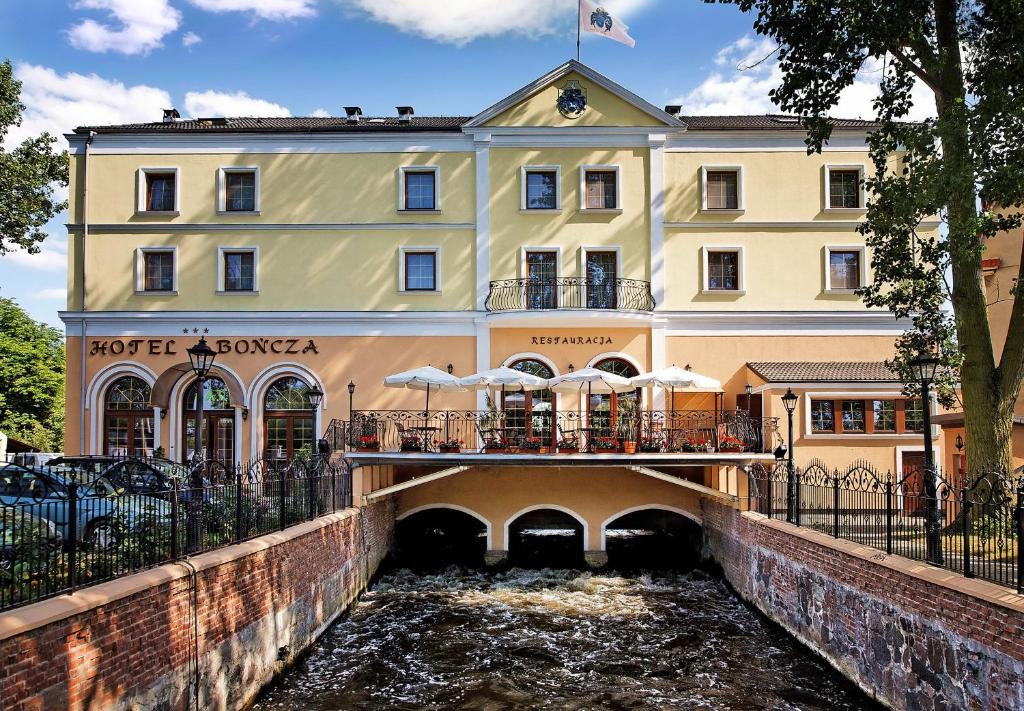 eine Brücke über einen Fluss vor einem Gebäude in der Unterkunft Hotel Bończa in Stettin