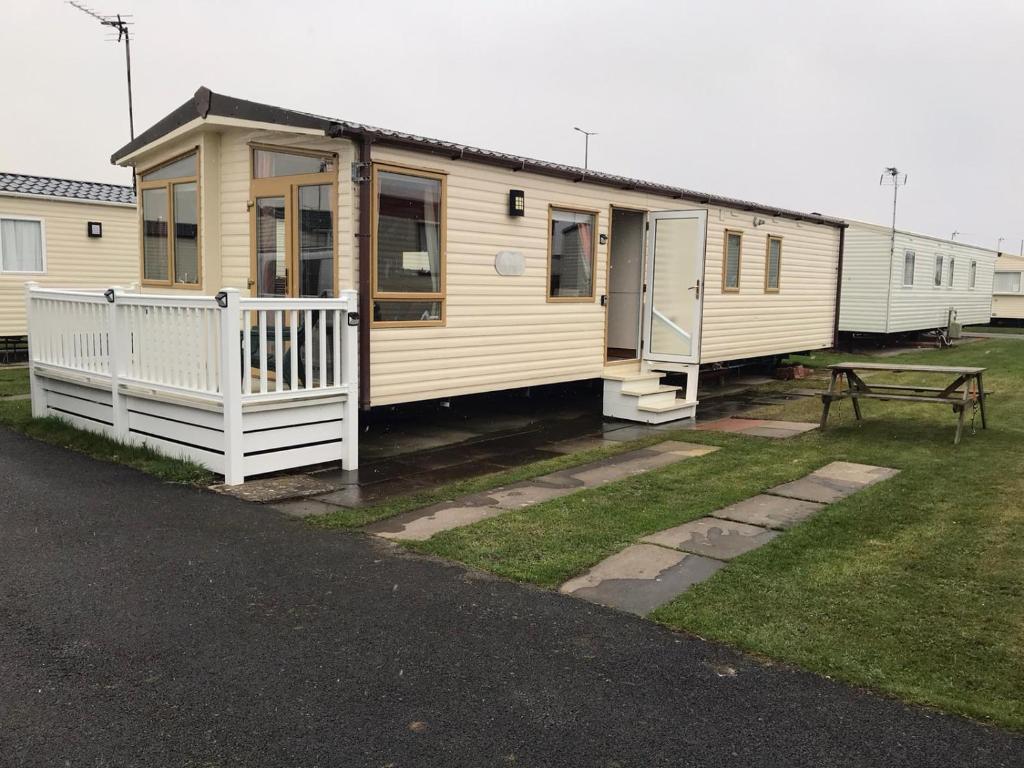 a row of mobile homes parked in a yard at Two x 8 Berth static caravan on Lyons Robin Hood Rhyl North wales in Meliden