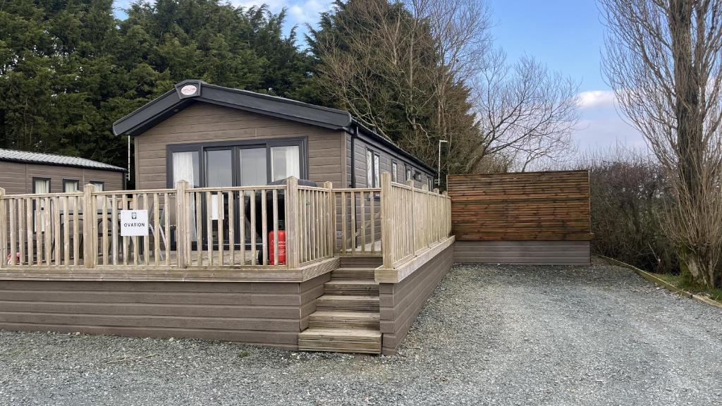 a house with a wooden deck and a fence at 2-Bed Lodge Near Garstang and Poulton-Le-Fylde in Preston