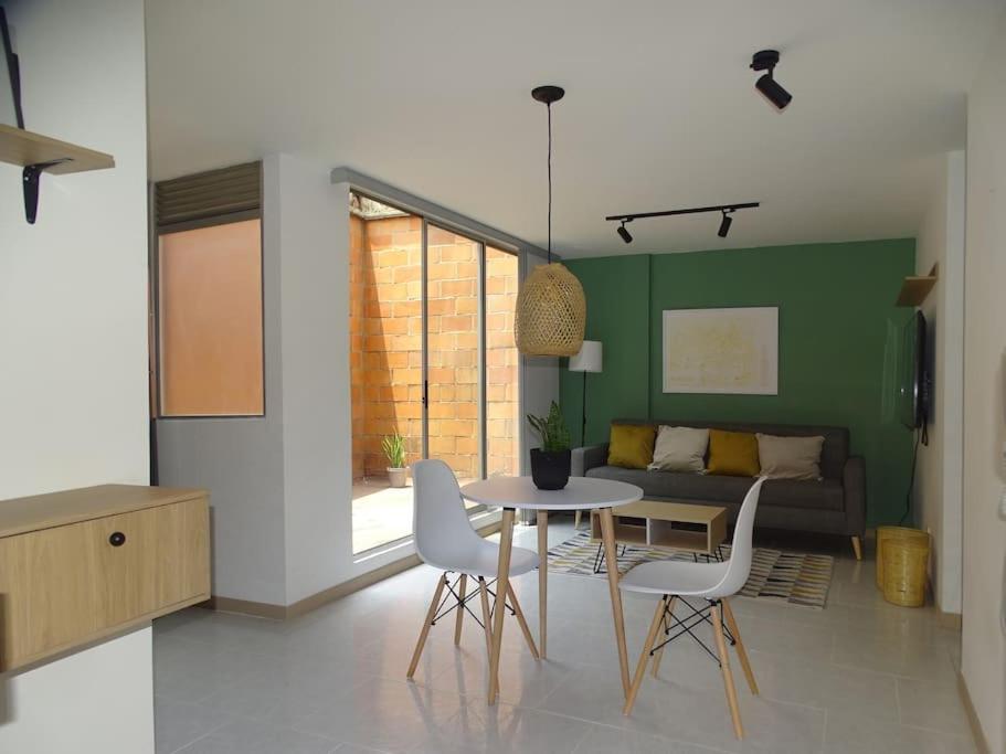 a living room with a table and chairs and a couch at Cozy Apartment in Historic Prado with adjustable desk and 4K Monitor in Medellín