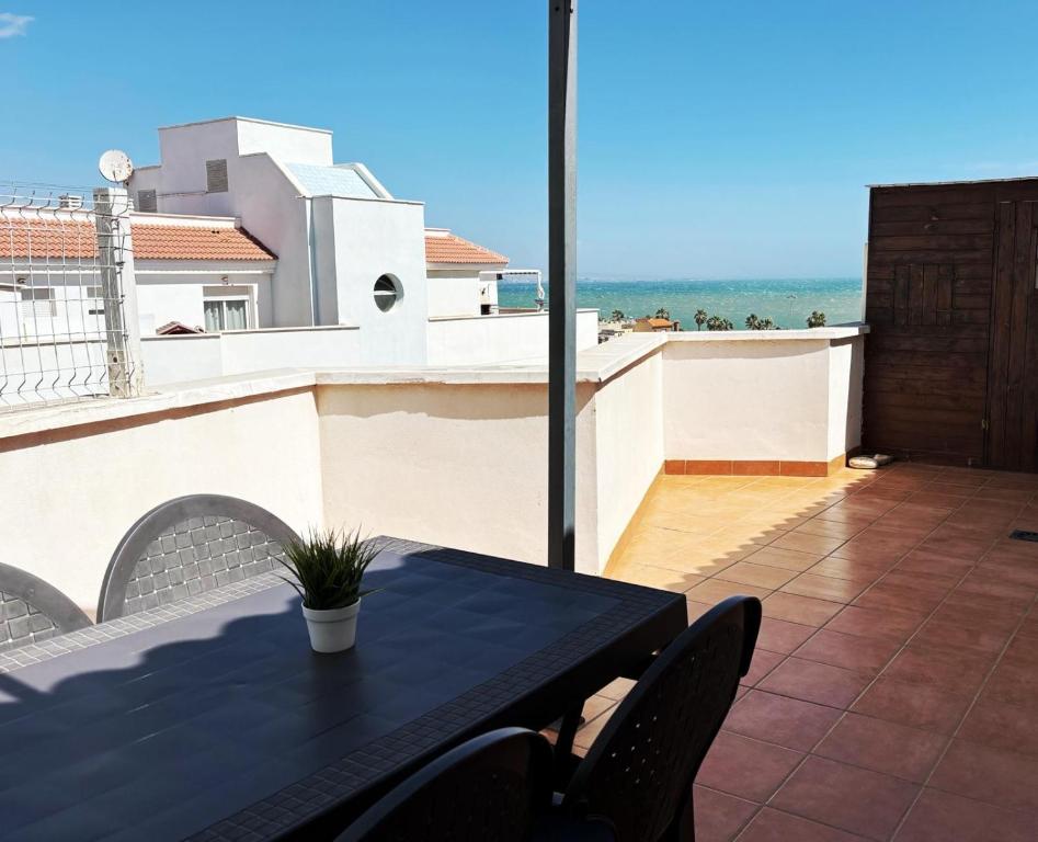 een tafel op een balkon met uitzicht op de oceaan bij Ático en pimera línea de playa in Roquetas de Mar