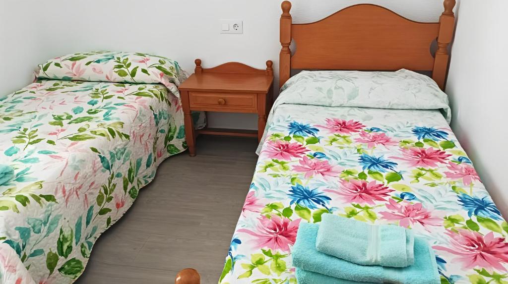 1 Schlafzimmer mit 2 Betten und einem Kopfteil aus Holz in der Unterkunft Apartamento reformado con piscina y vistas in Garrucha