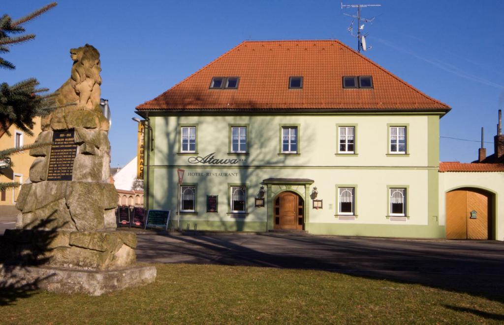 ein großes weißes Gebäude mit rotem Dach in der Unterkunft Hotel Atawa in Raby