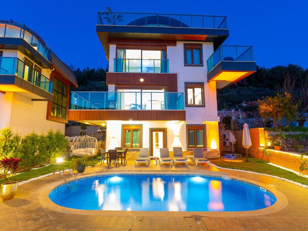 a villa with a swimming pool in front of a house at Alanya Luxury Villas in Alanya