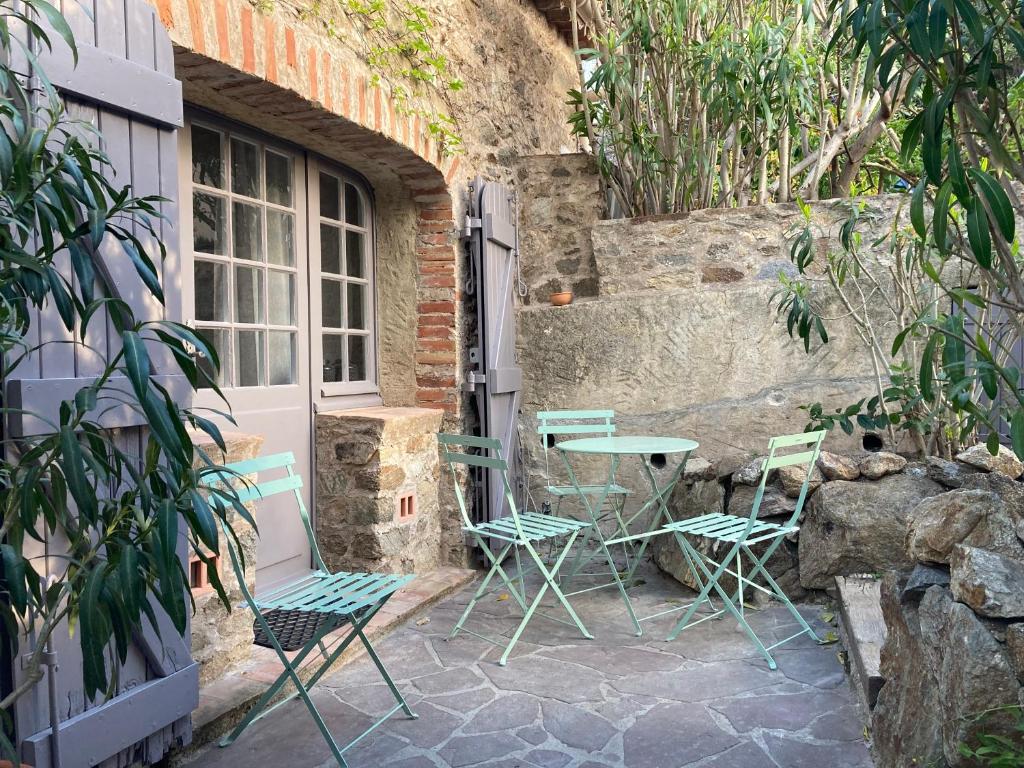 um pátio com cadeiras e uma mesa em frente a um edifício em Belle Maison de village em Ramatuelle