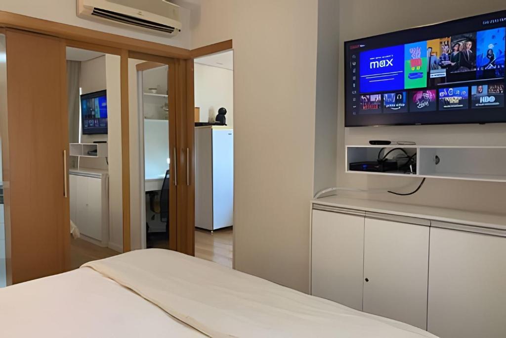 een slaapkamer met een tv aan de muur bij Get a Flat 601 Ibirapuera -Jardins in Sao Paulo