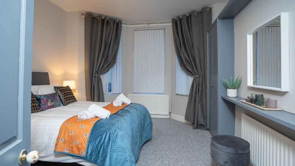 a bedroom with a bed with an orange blanket at 1 BDR apartment at QUEENS UNI by Belfast City Breaks in Belfast