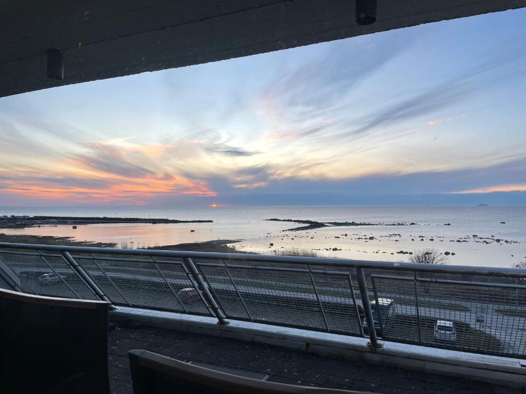 Visby Snäck Lägenheter, Havsutsikt في فيسبي: اطلالة على الشاطئ وقت الغروب من الشرفة