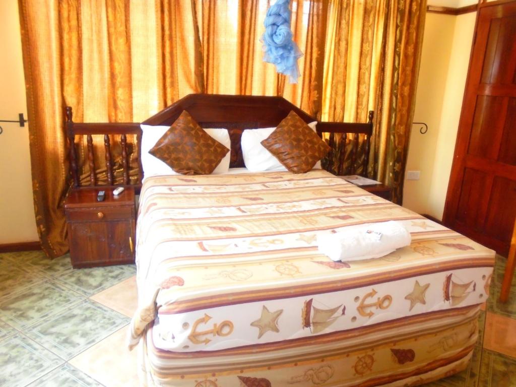 a bedroom with a large bed with a wooden headboard at White Rose Lodge in Livingstone