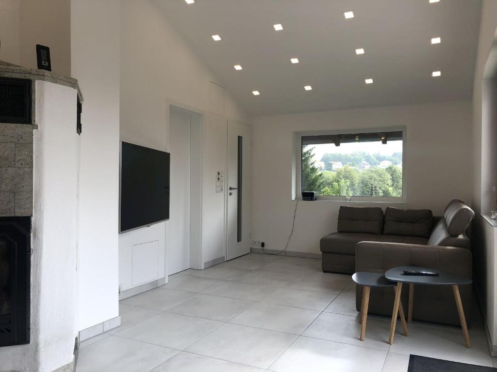 sala de estar con sofá y TV en Ferienhaus Schönach, en Herdwangen-Schönach