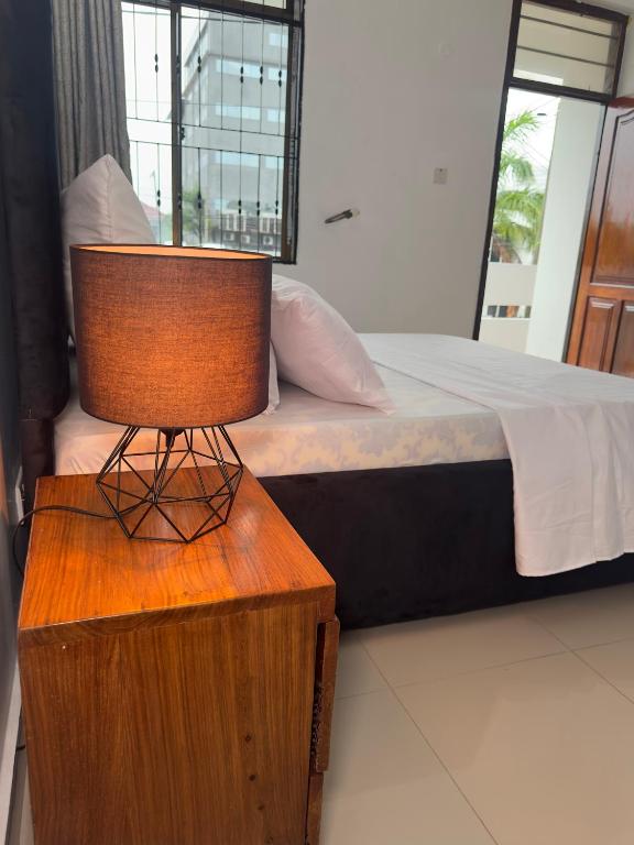 a bedroom with a bed and a table with a chair at Stay with soniyah 2 in Dar es Salaam