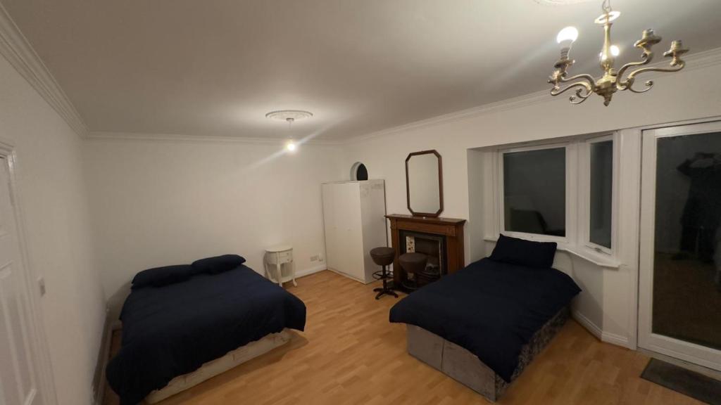 1 dormitorio con 2 camas y lámpara de araña en Huge Family Room Clontarf House-4, en Dublín