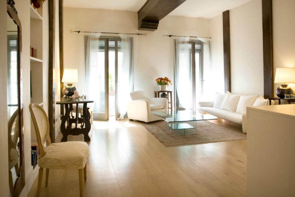 a living room with white furniture and a table at Milano Suites in Milan