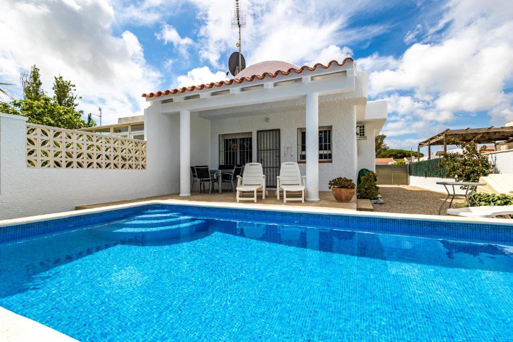 a villa with a swimming pool in front of a house at Chalet El Garxal Riumar Pura Natura in Riumar