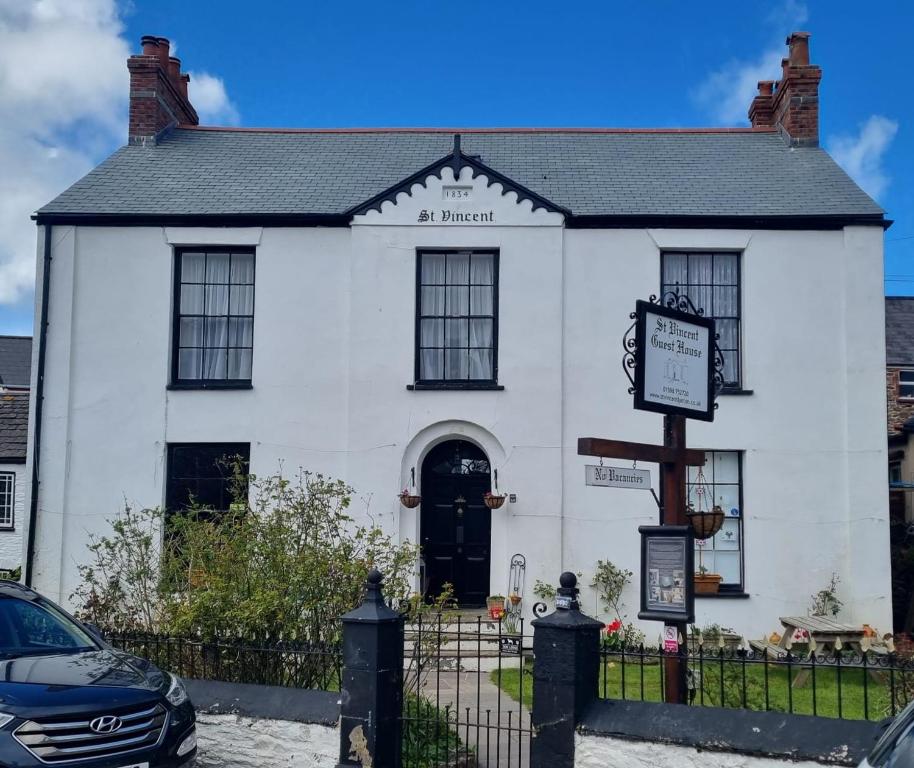 a white building with a sign in front of it at St Vincent Guest House in Lynton