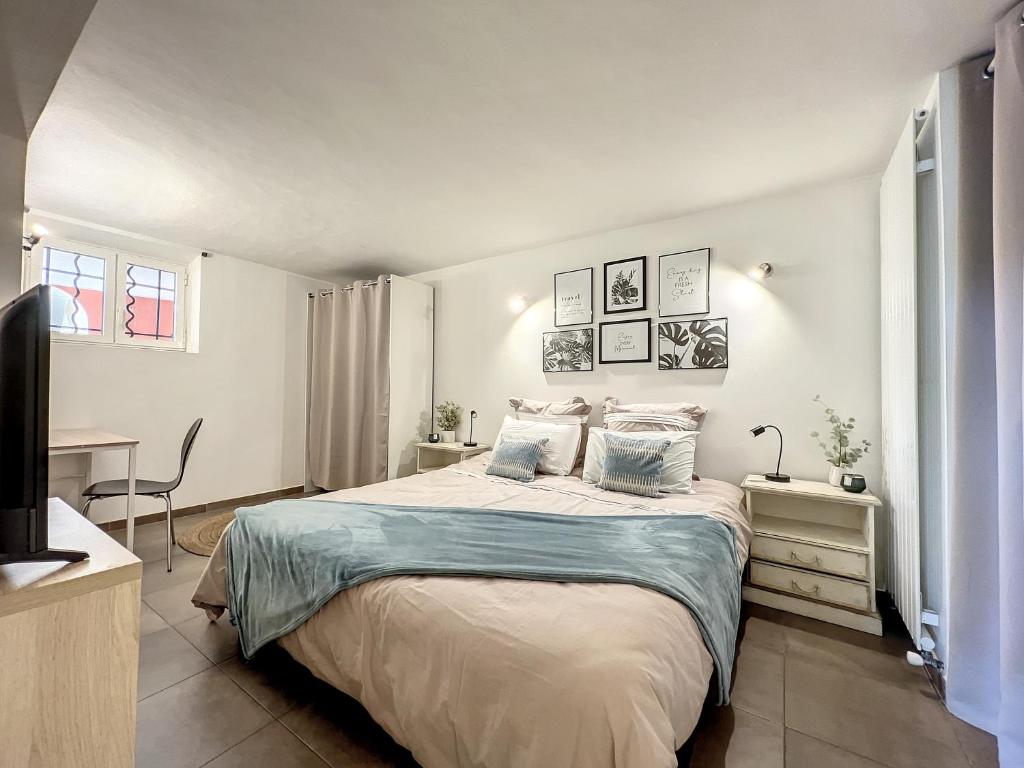 une chambre avec un lit, un bureau et une télévision dans l'établissement Antibes chez Elodie, à Antibes