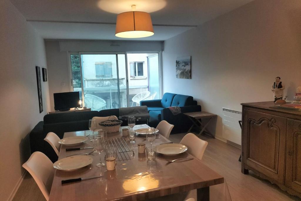 un salon avec une table et des chaises et un salon dans l'établissement Touquet nest near the beach, à Le Touquet-Paris-Plage