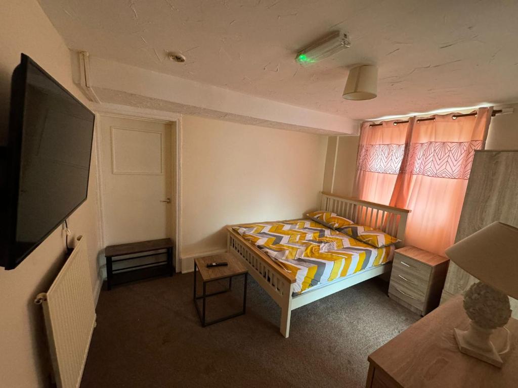 um quarto com uma cama e uma televisão de ecrã plano em One Bedroom Flat with on premises parking em Walsall