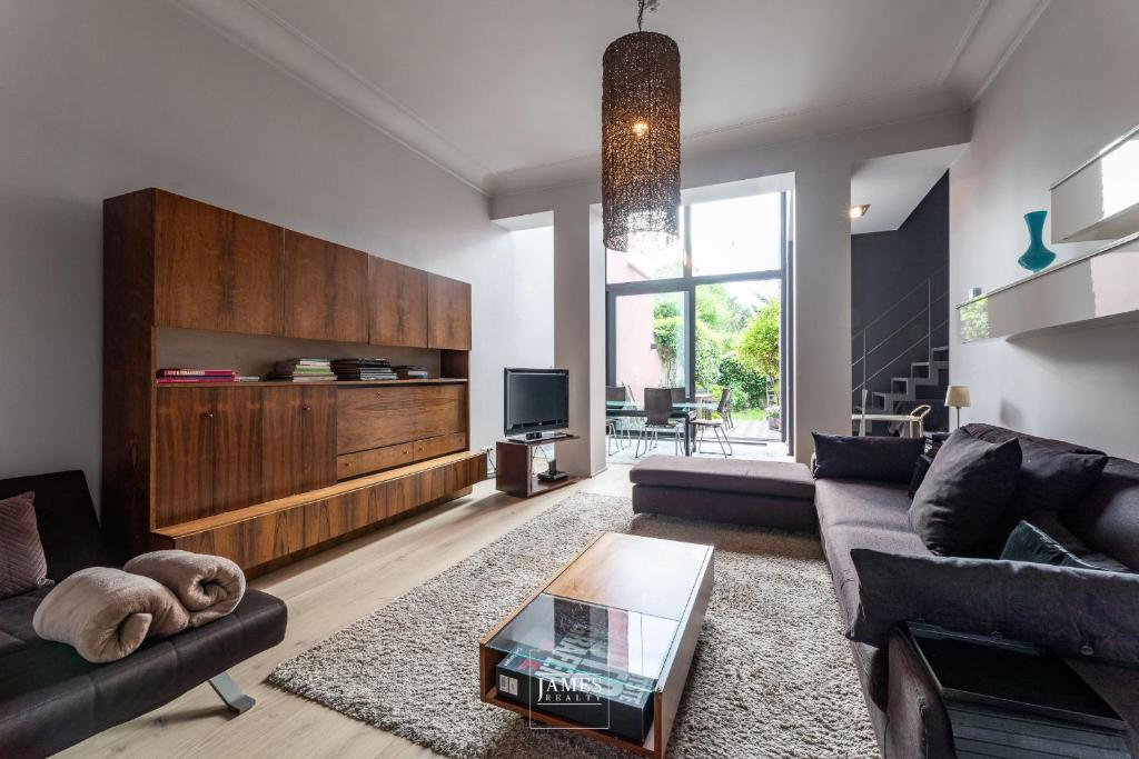 a living room with a couch and a table at Rez/duplex 3 ch et jardin in Brussels