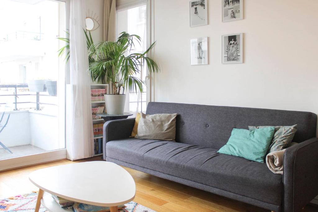 a living room with a couch and a table at Spacious family nest near La Villette in Pantin