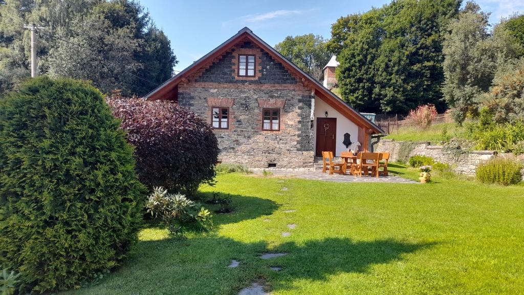 an old stone house with a grass yard at Chalupa u Anenské in Žďárský Potok