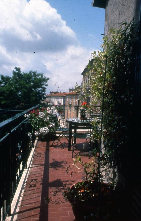 a patio with a table and flowers on a balcony at Le Camere Di Paolino in Manciano