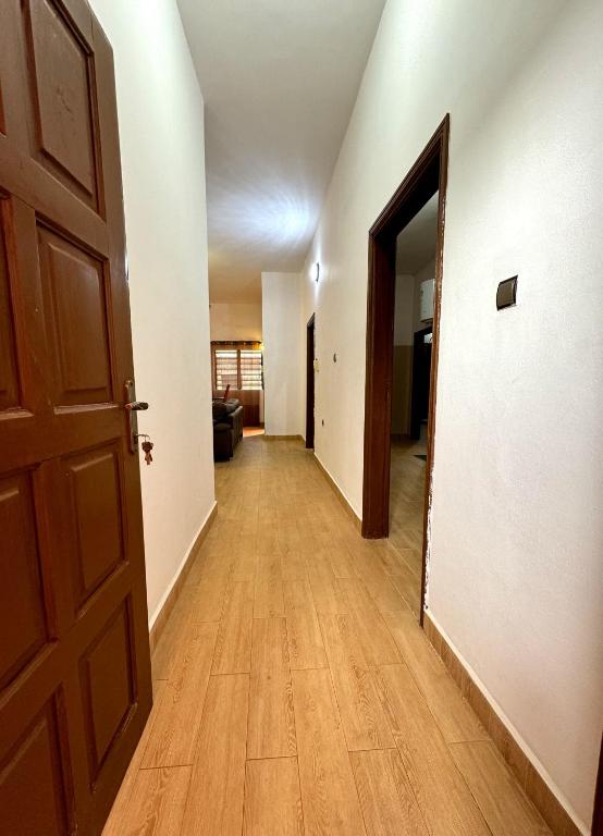 um corredor vazio com uma porta aberta e um piso de madeira em SECRET D'OFÈ em Porto Novo