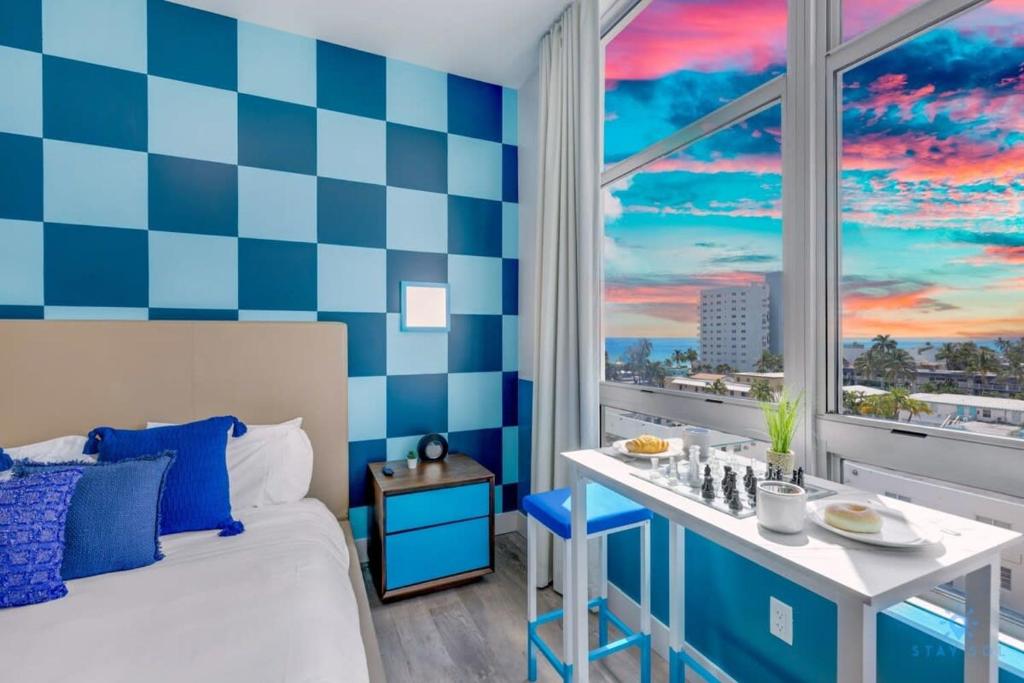 a bedroom with a blue and white checkerboard wall at Rooftop Pool & Hot Tub - Gym - Near Beach in Hollywood