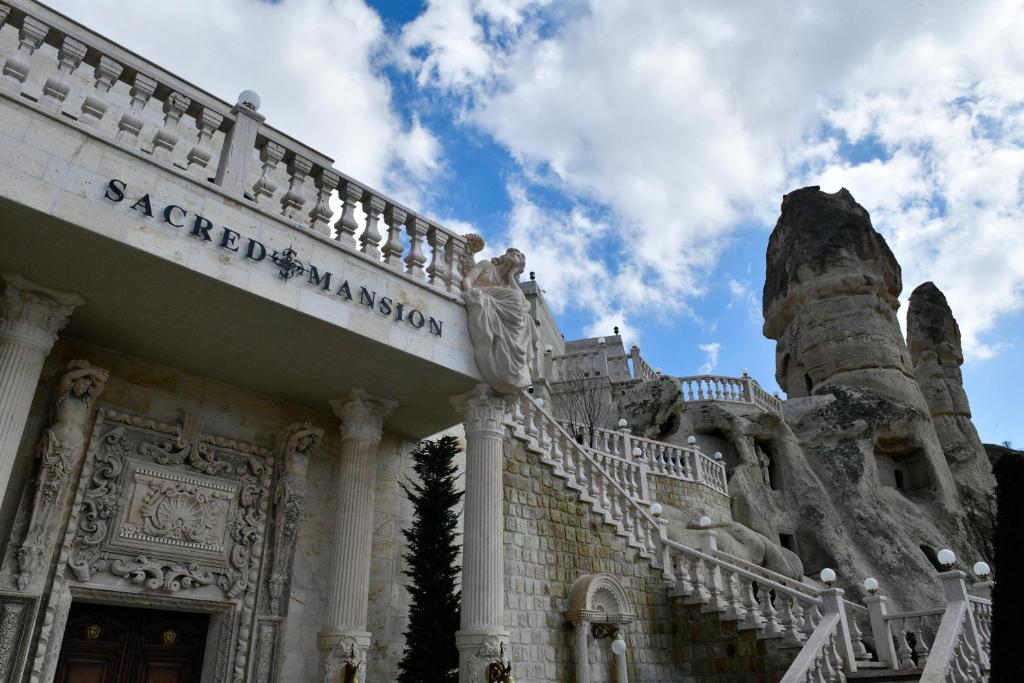 un edificio antiguo con una escalera delante en Sacred Mansion en Goreme