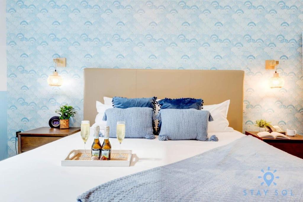 a bedroom with a white bed with blue wallpaper at Best Stay - Rooftop Pool & Hot Tub - Hollywood Beach in Hollywood
