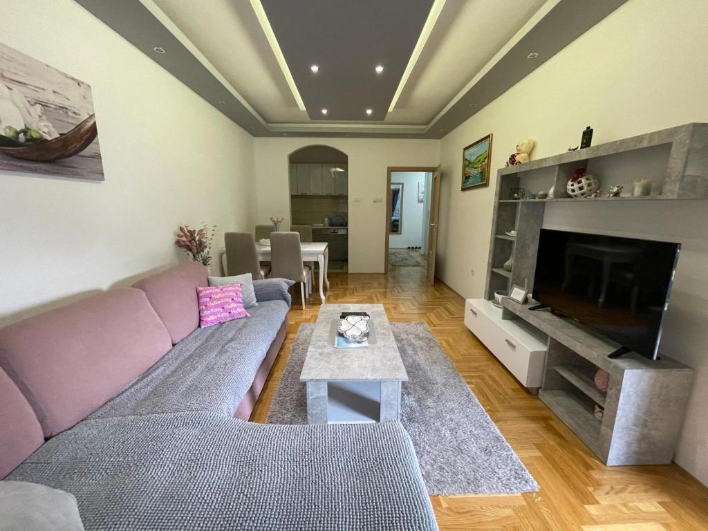 een woonkamer met een bank en een tv bij Oasis of Peace in Trebinje