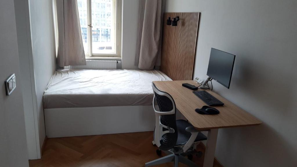 Zimmer mit einem Schreibtisch, einem Computer und einem Bett in der Unterkunft Harmony Residence One in Prag