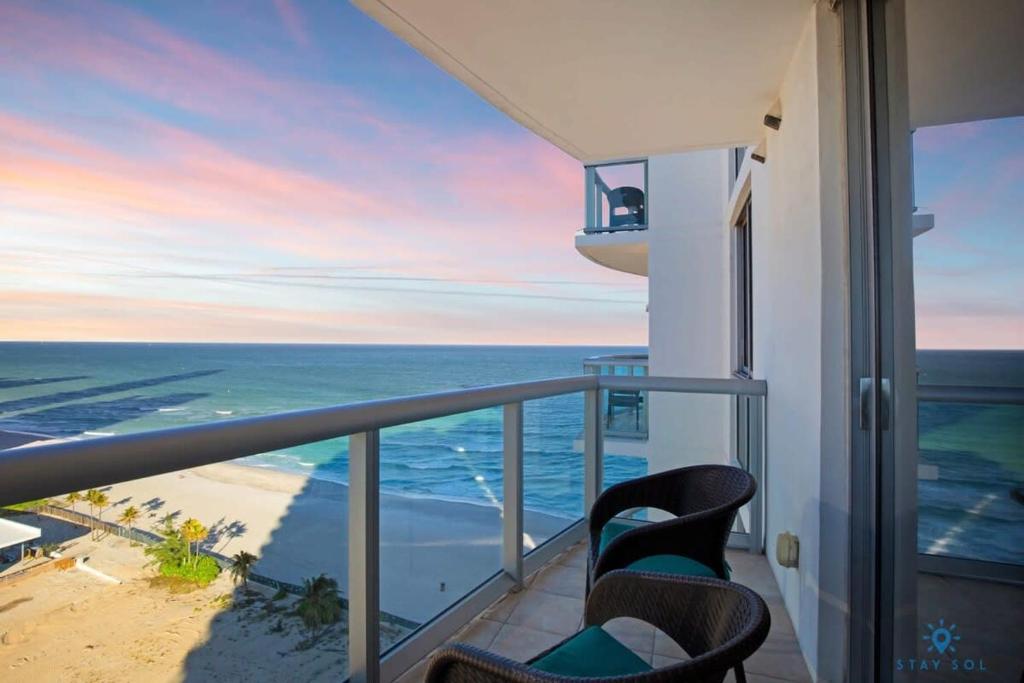 a balcony with two chairs and a view of the ocean at Beachfront Resort - Pool - Ocean View Balcony- Gym in Miami Beach