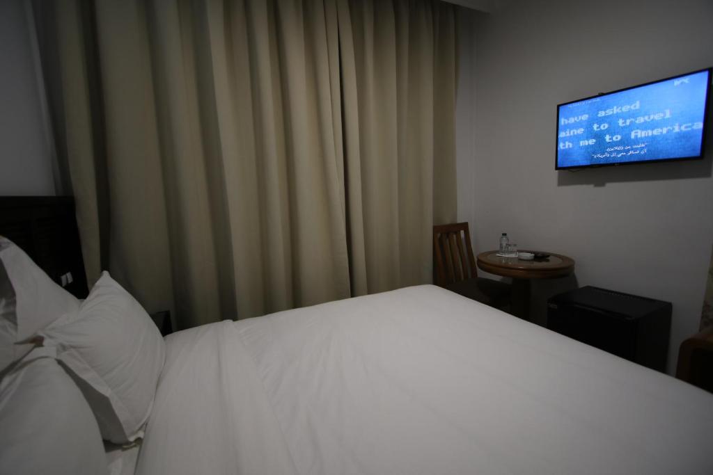 Una televisión o centro de entretenimiento en Hôtel Mansour