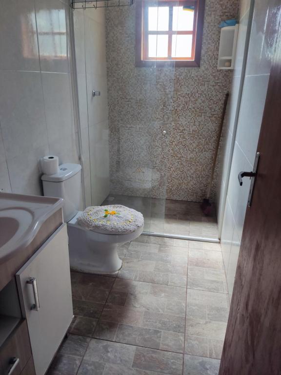 uma casa de banho com um chuveiro, um WC e um lavatório. em Sitio em Maquiné