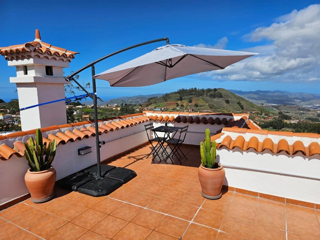 a patio with an umbrella on top of a house at Casa Ramon B&B in La Esperanza