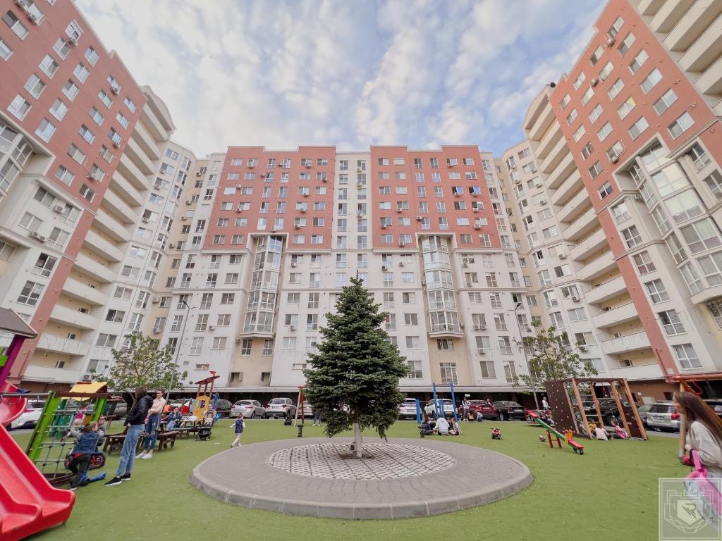 drzewo w środku parku z wysokimi budynkami w obiekcie RentHouse Apartments Elegant w Kiszyniowie