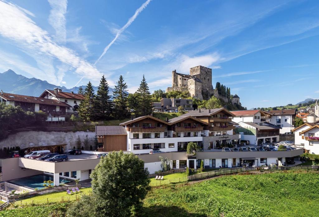 un complejo con un castillo en la cima de una montaña en Alpin Chalet am Burgsee en Ladis