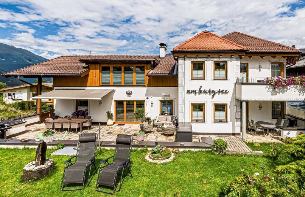 a house with a yard with chairs and a patio at Appartements Am Burgsee in Ladis