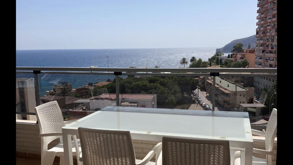 a white table and chairs on a balcony with the ocean at Plaza Mayor in Calpe