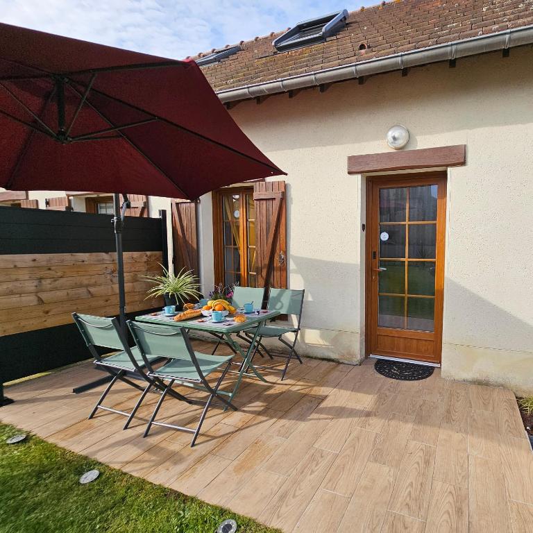 un patio avec une table, des chaises et un parasol dans l'établissement Ô P'tit Billard Baventais, à Bavent