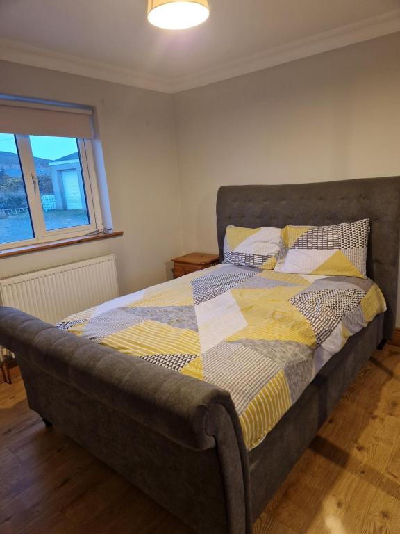 ein Bett mit einer Decke in einem Schlafzimmer in der Unterkunft Radharc Na Mara in Letterkenny