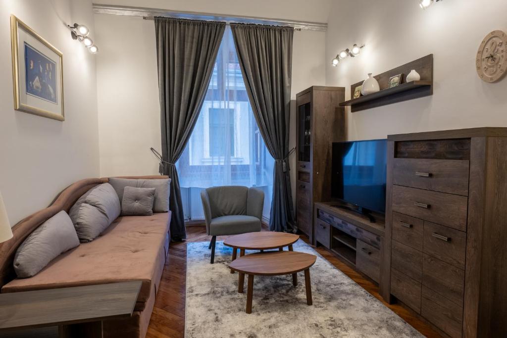 Una sala de estar con un sofá y un televisor. en Little Vienna Silver Apartment, en Varaždin
