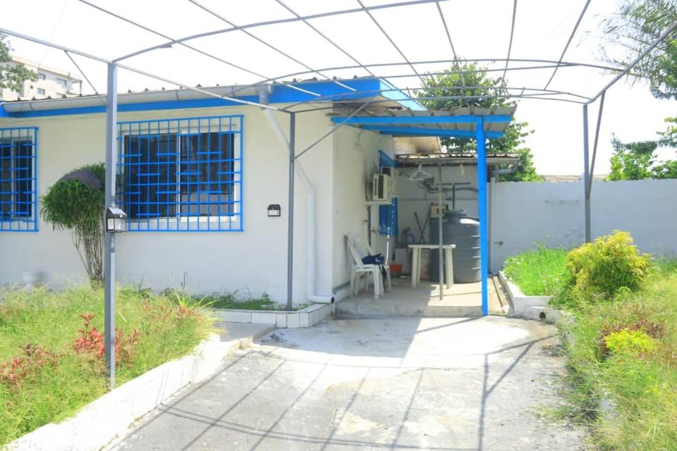 a house with a blue roof and a patio at Résidence reine lumière in Libreville