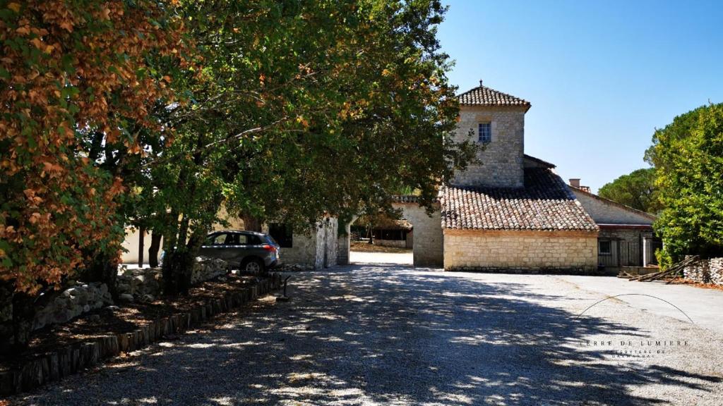 um carro estacionado numa estrada em frente a um edifício em Les chambres du Presbytère em Montagudet